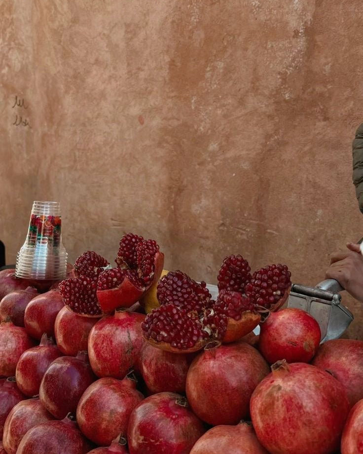 Pomegranates on a table with a plain wall background
